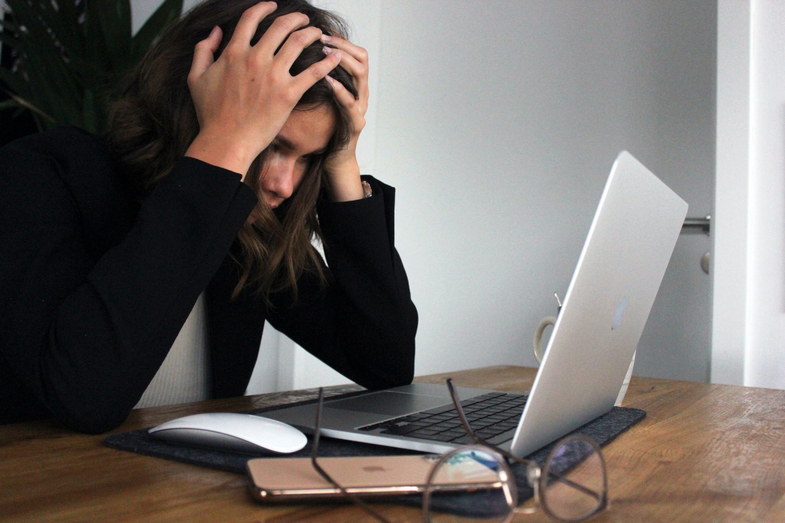 Eine Frau wirkt gestresst vor ihrem Laptop