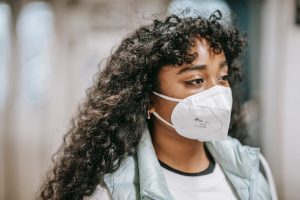 Eine Frau trägt eine Maske. Long Covid Behandlung